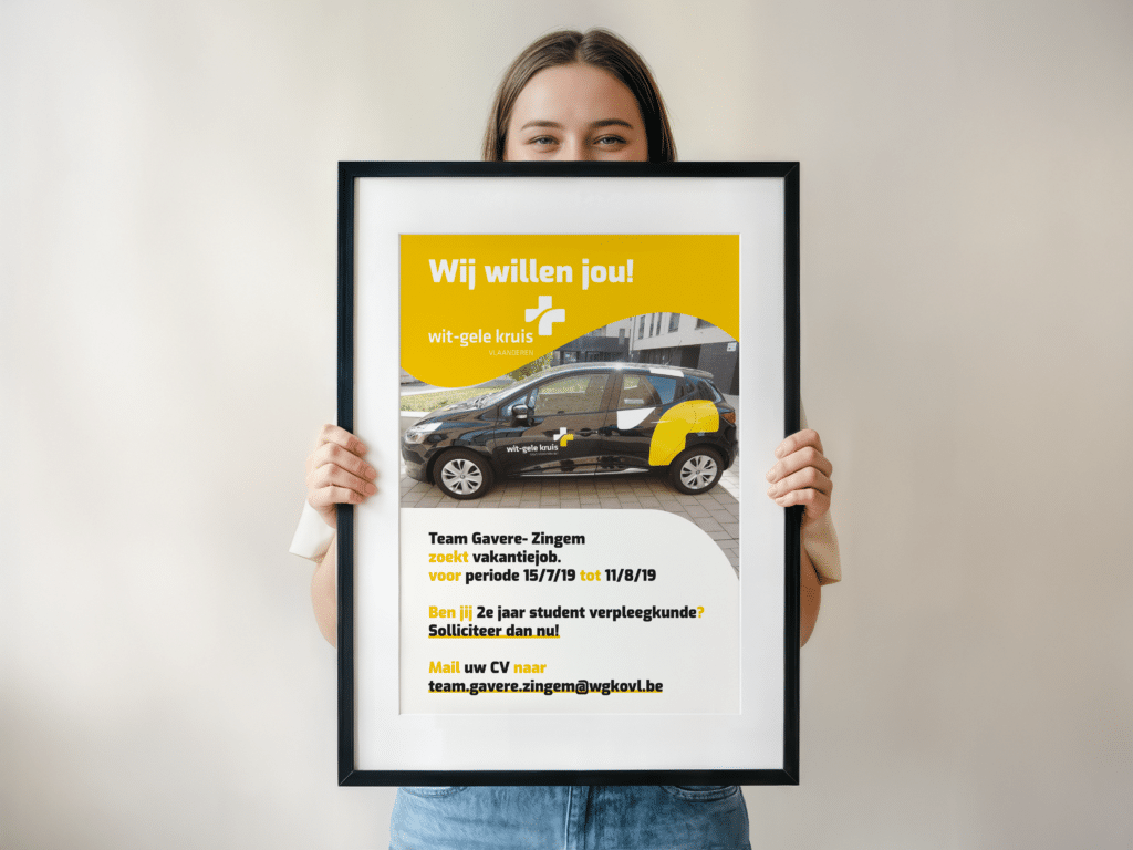 Affiche "We want you" van het Wit-Gele-Kruis Gavere. Vastgehouden in een kader door een jonge dame.